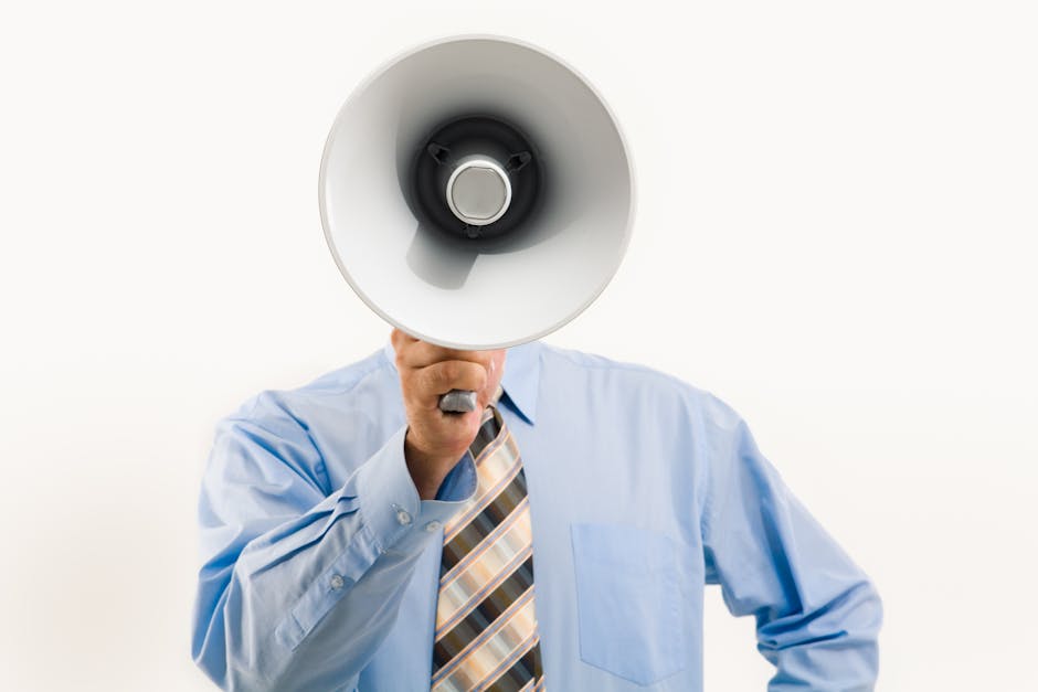 Businessman in blue shirt holding megaphone, symbolizing leadership and communication